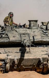 Israeli soldiers drive a tank at a staging ground near the border with the Gaza Strip, in southern Israel, Sunday, May 5, 2024. 