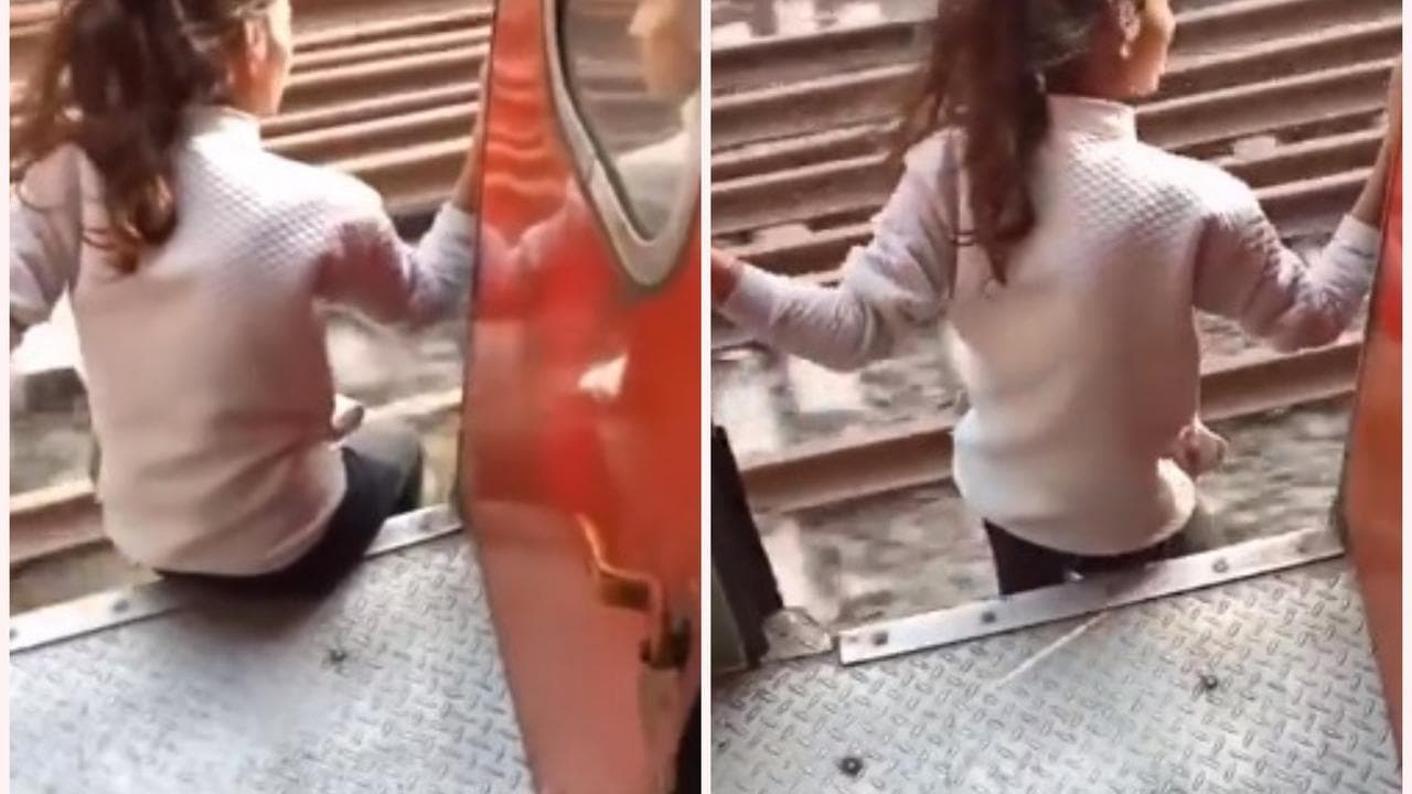 A girl jumps out of the train while shooting a reel. 