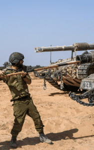 Israeli soldiers work on a tank at a staging ground near the border with the Gaza Strip, in southern Israel, Sunday, May 5, 2024. 
