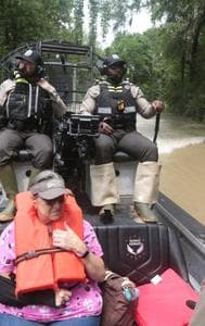 Texas Parks & Wildlife Department game wardens use a boat to rescue residents from floodwaters in Liberty County, Texas, on Saturday, May 4, 2024. 