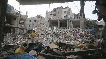 Palestinians inspect rubble in Gaza