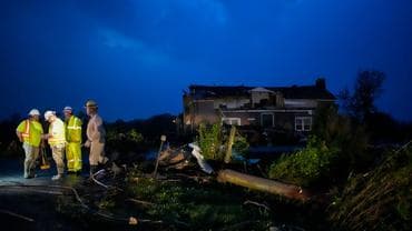 Utility workers survey storm damage along Cothran Road, Wednesday, May 8, 2024, in Columbia, Tenn. 